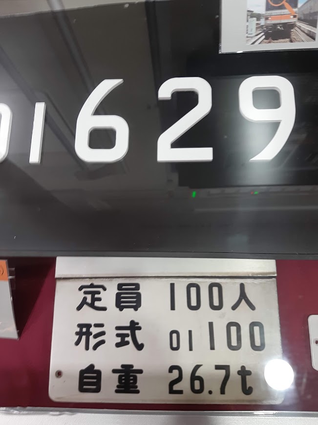 大きな黒い数字「1629」が書かれたボードと、その下の小さな白いプレート。「定員 100人」「形式 01 100」「自重 26.7t」という文字と数字が読み取れる。